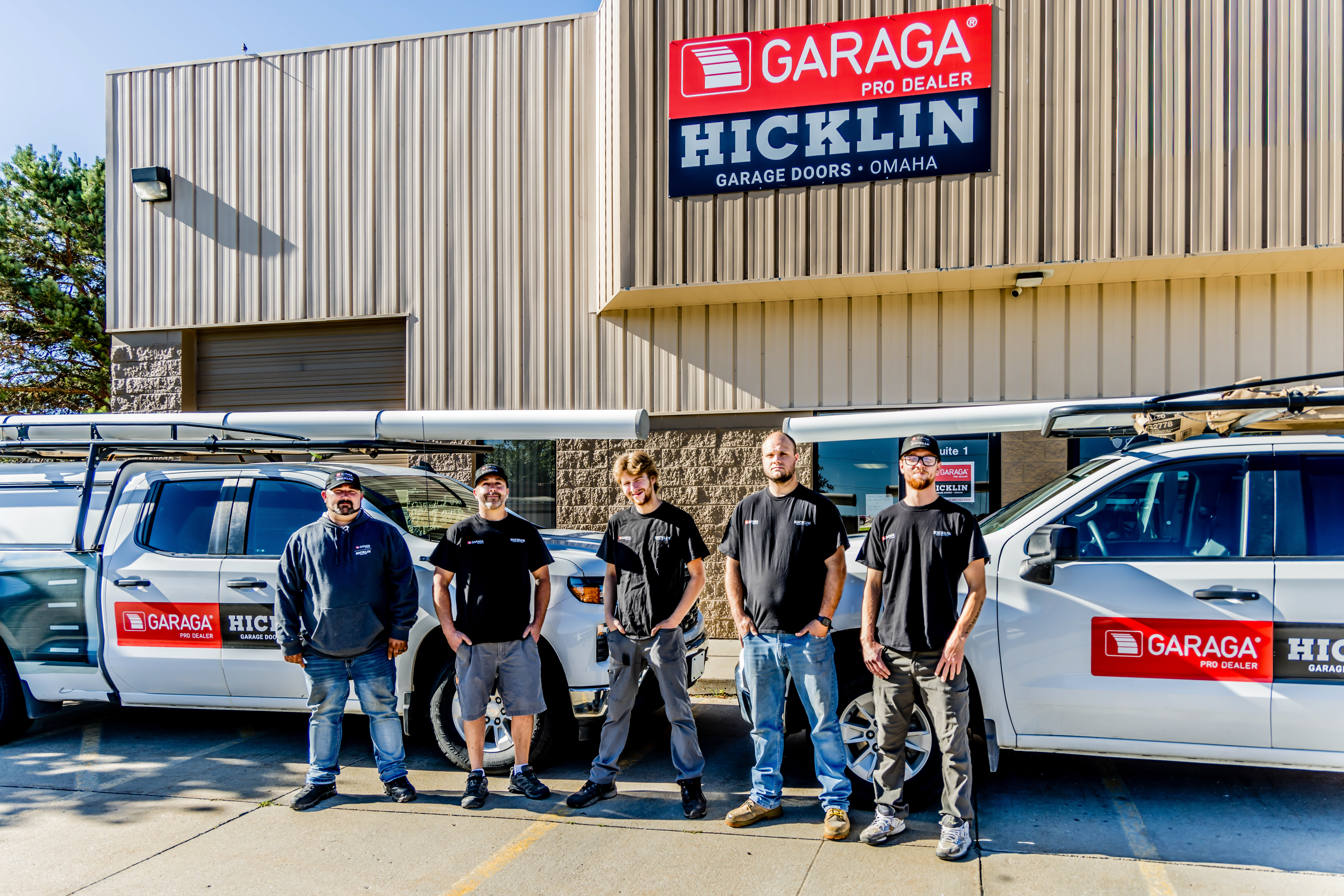Garage door installers in front of their trucks at their office in Omaha