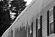 Freezing weather conditions form a row of icicles on a house’s exterior.